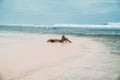 Gorgeous young girl in a beige bikini lies on the beach, sunbathing near the ocean. A model with a body and a Royalty Free Stock Photo