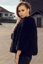 Gorgeous young model woman with perfect brunnete hair looking at camera posing in the city wearing black jacket on