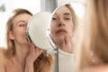 Gorgeous young naked woman looking at mirror. Royalty Free Stock Photo