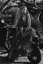 Beautiful woman wearing dress posing seated on motorcycle black and white image Royalty Free Stock Photo