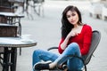 Gorgeous young woman with cup of coffee in city street. Coffee break. Stylish hipster girl drinking coffee in street. Royalty Free Stock Photo