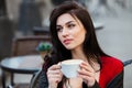 Gorgeous young woman with cup of coffee in city street. Coffee break. Stylish hipster girl drinking coffee in street. Royalty Free Stock Photo