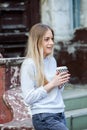 Gorgeous young woman with cup of coffee in city street. Coffee break. Coffee to go. Stylish hipster girl drinking coffee in street Royalty Free Stock Photo