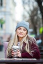 Gorgeous young woman with cup of coffee in city street. Coffee break. Coffee to go. Stylish hipster girl drinking coffee in street Royalty Free Stock Photo