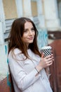 Beautiful woman holding paper coffee cup in the city Young stylish woman drinking coffee to go in a city street Royalty Free Stock Photo