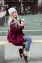 Gorgeous young woman with cup of coffee in city street. Coffee break. Coffee to go. Stylish hipster girl drinking coffee in street Royalty Free Stock Photo