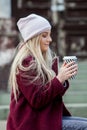 Gorgeous young woman with cup of coffee in city street. Coffee break. Coffee to go. Stylish hipster girl drinking coffee in street Royalty Free Stock Photo