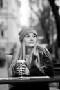 Gorgeous young woman with cup of coffee in city street. Coffee break. Coffee to go. Stylish hipster girl drinking coffee in street Royalty Free Stock Photo