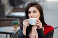 Gorgeous young woman with cup of coffee in city street. Coffee break.  Stylish hipster girl drinking coffee in street. Royalty Free Stock Photo