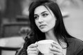 Gorgeous young woman with cup of coffee in city street. Coffee break. Stylish hipster girl drinking coffee in street. Royalty Free Stock Photo