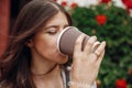 Gorgeous young woman drinking cup of coffee and smiling in city Royalty Free Stock Photo