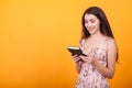 Gorgeous young woman holdin a book in studio over yellow background Royalty Free Stock Photo