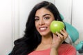 Gorgeous young woman holding green apple next to perfect white teeth Royalty Free Stock Photo