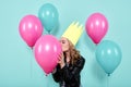 Gorgeous young woman in leather jacket and party hat kissing colourful balloon. Birthday party concept.