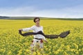 Gorgeous young woman playing with scarf in a canola field Royalty Free Stock Photo