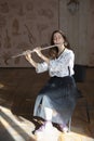 A gorgeous young woman sitting and playing the flute Royalty Free Stock Photo