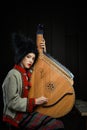 Gorgeous young woman in ukrainian traditional costume with ukrainian musical instrument bandura Royalty Free Stock Photo