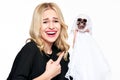 Gorgeous young woman in witch costume holding Halloween skeleton decoration laughing and pointing a finger at it.Halloween concept Royalty Free Stock Photo