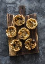 Gorgonzola, pears, honey, walnuts mini quiche on a wooden chopping board, top view on a dark background. Delicious appetizer,