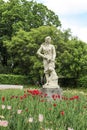 Gorky Central Park of Culture and Leisure. Garden sculpture of a girl with a gun in the park against a background of faded tulips