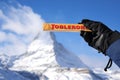Gornergrat, Zermatt/ Switzerland - December 12, 2022: Gloved hand holds Toblerone chocolate over blur the Matterhorn mountain