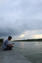 Gorontalo-Indonesia, December 2022 - A teenage boy is fishing by the river in the afternoon Royalty Free Stock Photo
