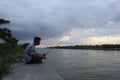 Gorontalo-Indonesia, December 2022 - A teenage boy is fishing by the river in the afternoon Royalty Free Stock Photo