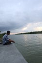 Gorontalo-Indonesia, December 2022 - A teenage boy is fishing by the river in the afternoon Royalty Free Stock Photo