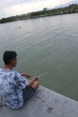 Gorontalo-Indonesia, December 2022 - A teenage boy is fishing by the river in the afternoon Royalty Free Stock Photo