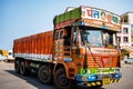 Gos, India - 2019. Colorful cargo truck under a summer blue sky with rich decorative paintings, typical for the trucks in India.