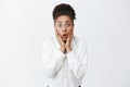 Gosh, what happened to your hair. Portrait of shocked and stunned beautiful dark-skinned female friend with curly hair