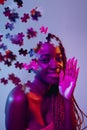 Creative collage of young african woman isolated over purple background in neon light. Female head consist of puzzle