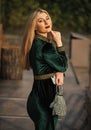 She got great style. blond girl care gem stone handbag or purse. glam clutch accessory. elegant woman in green velour