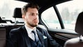 Stressed young businessman sitting in luxury car Royalty Free Stock Photo