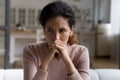 Thoughtful unhappy latin female sit on couch with sad look