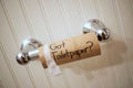 `Got Toilet Paper`, written in sharpie on cardboard toilet paper roll that is left hanging on the spool, on the wall
