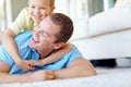 Got you, dad. Young boy and his father wrestling playfully in the lounge. Royalty Free Stock Photo