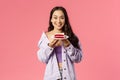 Got you some sweet dessert. Portrait of cheerful young asian girl holding piece of delicious cake, smiling happy, eating Royalty Free Stock Photo