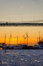 Gothenburg - sunset over fishing and sailing boats on frozen Gota river at Hisingsleden Bridge during winter Royalty Free Stock Photo