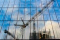 Gothenburg, Sweden - July 06 2019: Reflections of a frane and construction site in the glass facade of an office building Royalty Free Stock Photo