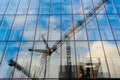 Reflections of a frane and construction site in the glass facade of an office building... Royalty Free Stock Photo