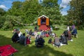 Kids and parents watching a puppetry show in a park..