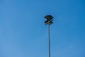 Large floodlights on a tall post by a football field..