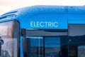 Front side detail of a blue electric bus..