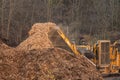 Wood chips dumped in a pile by a large industrial wood chipper..