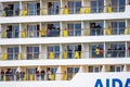 Passengers on a large cruise ship standing on their balconies as the ship departs.. Royalty Free Stock Photo