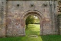 Gothic Archway With a Green Field and a Tree in the Background.