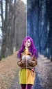 Gothic Girl with purple hair is standing with a burning glass in her hands in the alley in the autumn forest. Concept editing, pho Royalty Free Stock Photo