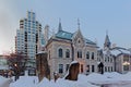 Gothic revival building with modern apartment tower behin o a winter day with snow