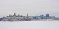 Parliament hill and supreme court in Ottawa, seen from across Ottawa river on a cold winter day with snow Royalty Free Stock Photo